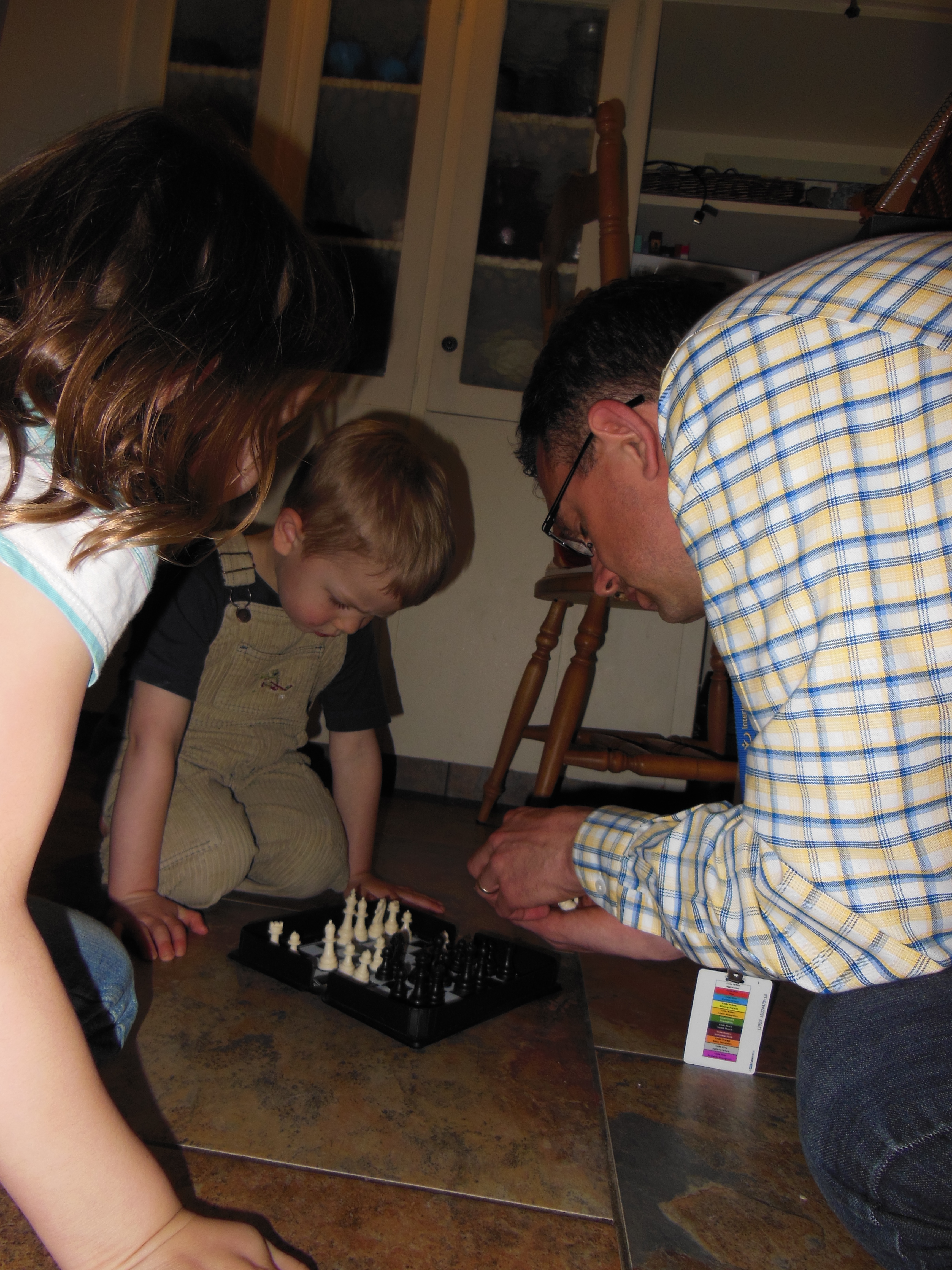 Rachel and Zach playing chess with dad