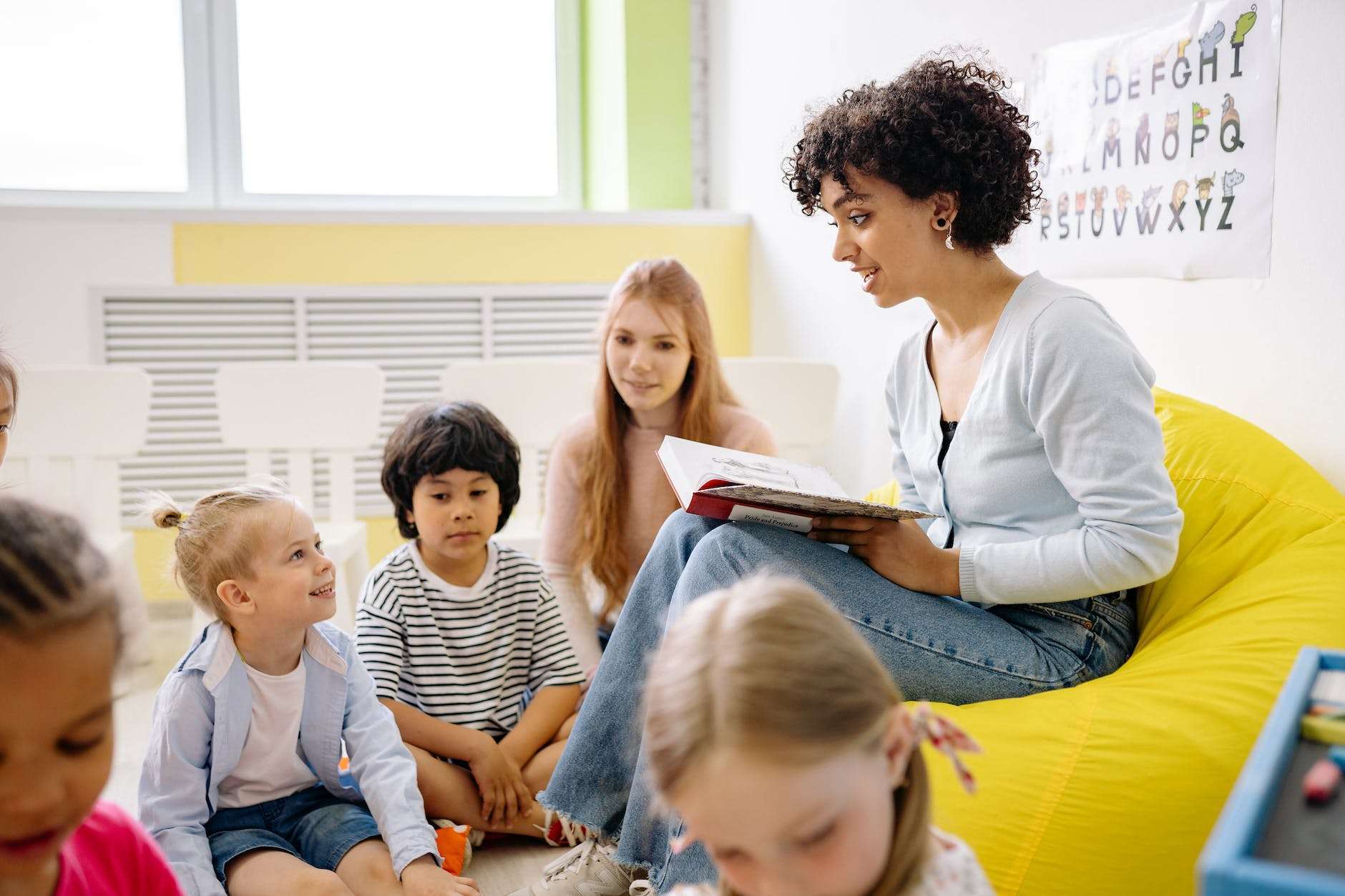 woman reading a book to the children: teaching french in a child-led way  