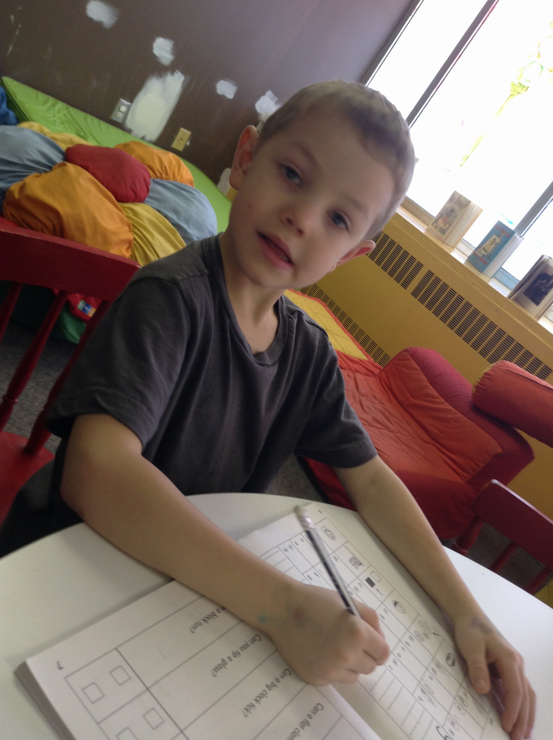 Zach doing a workbook at the library: homeschool kindergarten