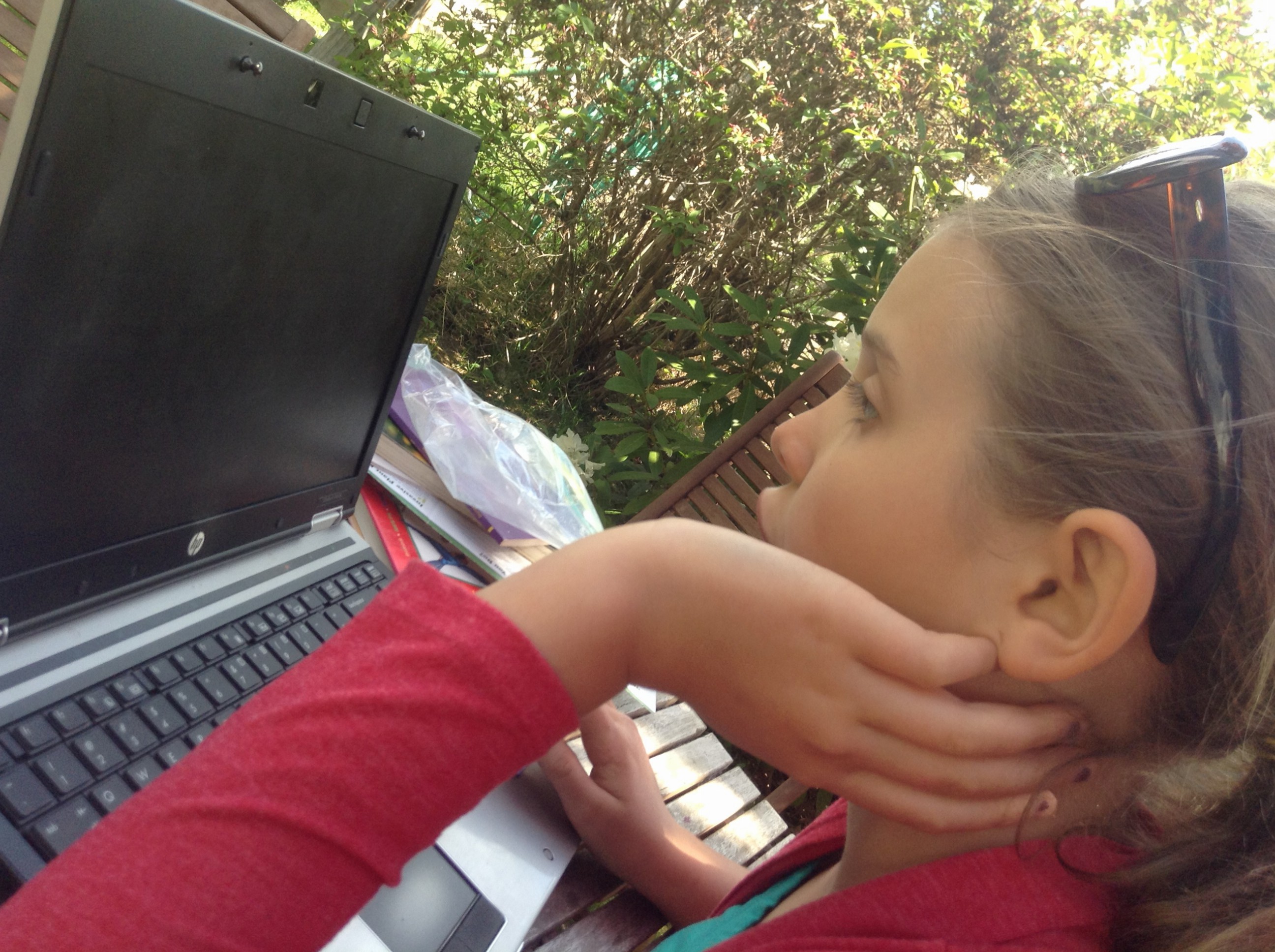Madelyn on the computer in the garden: is this formal studies or unschooling?