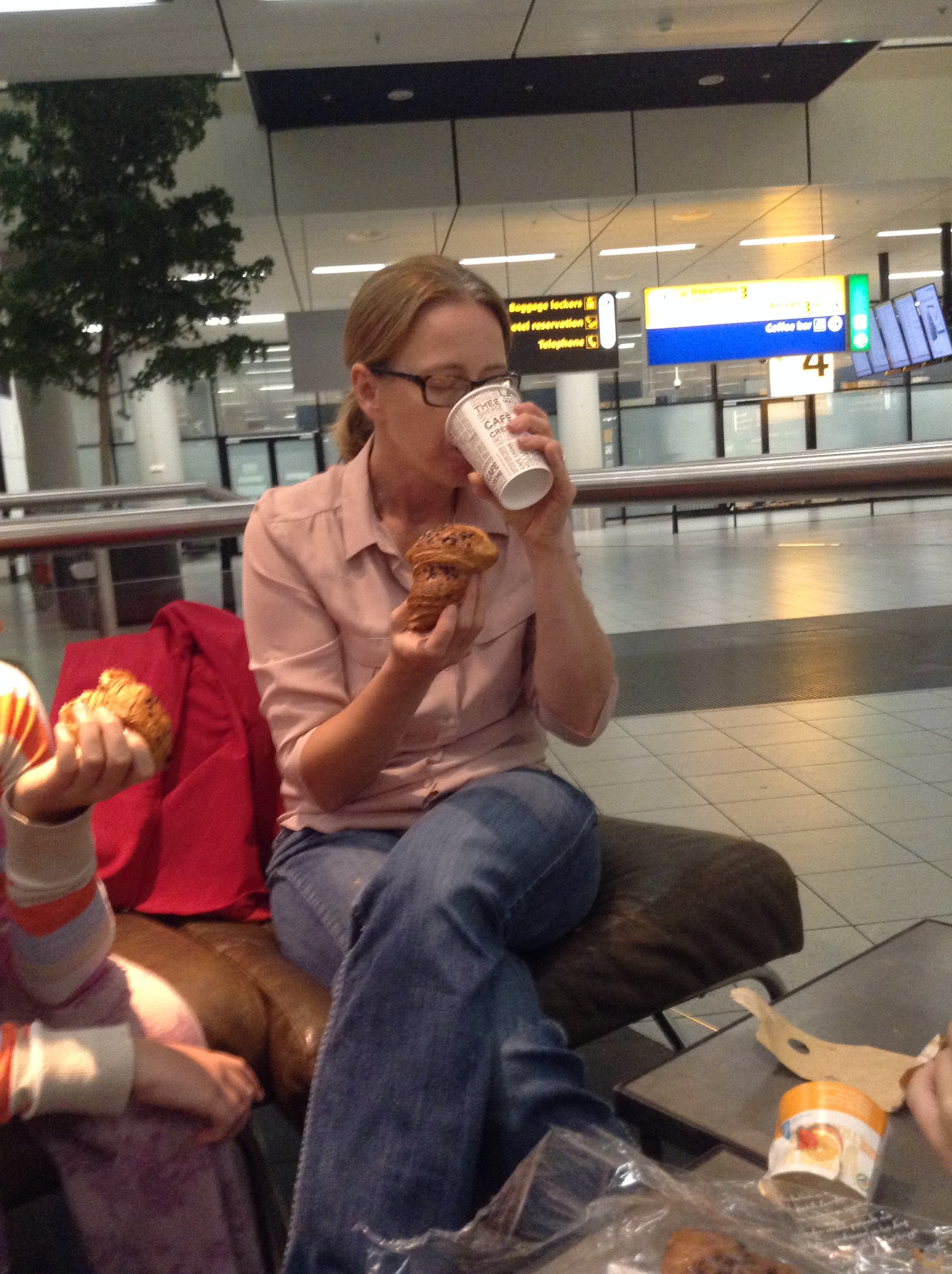 Eating a chocolate croissant and coffee in the Amsterdam airport