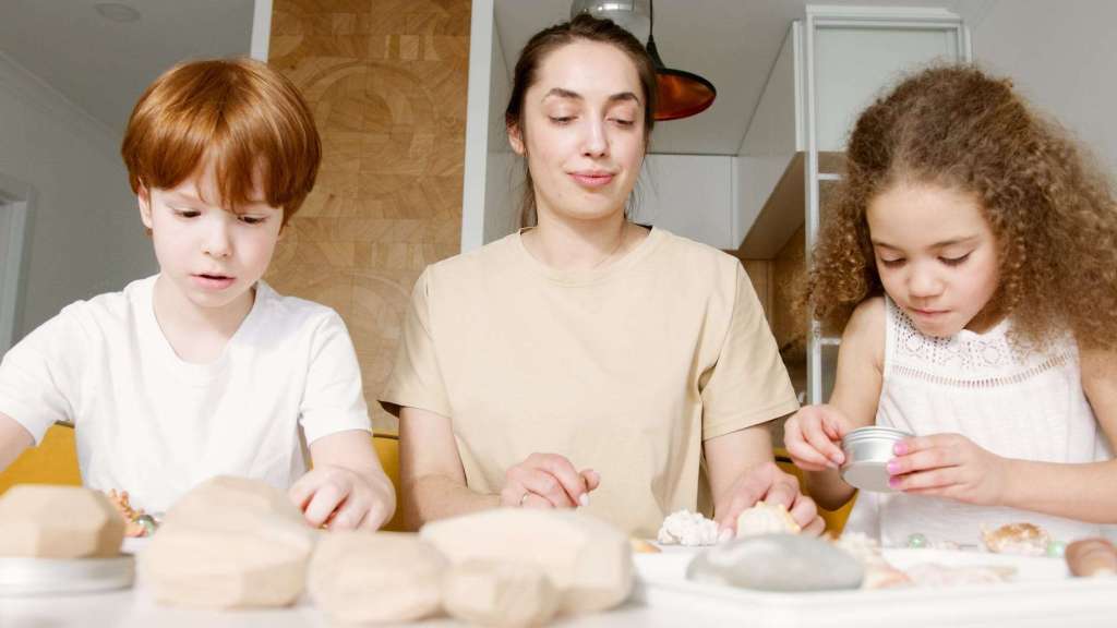 a woman and kids making arts and crafts