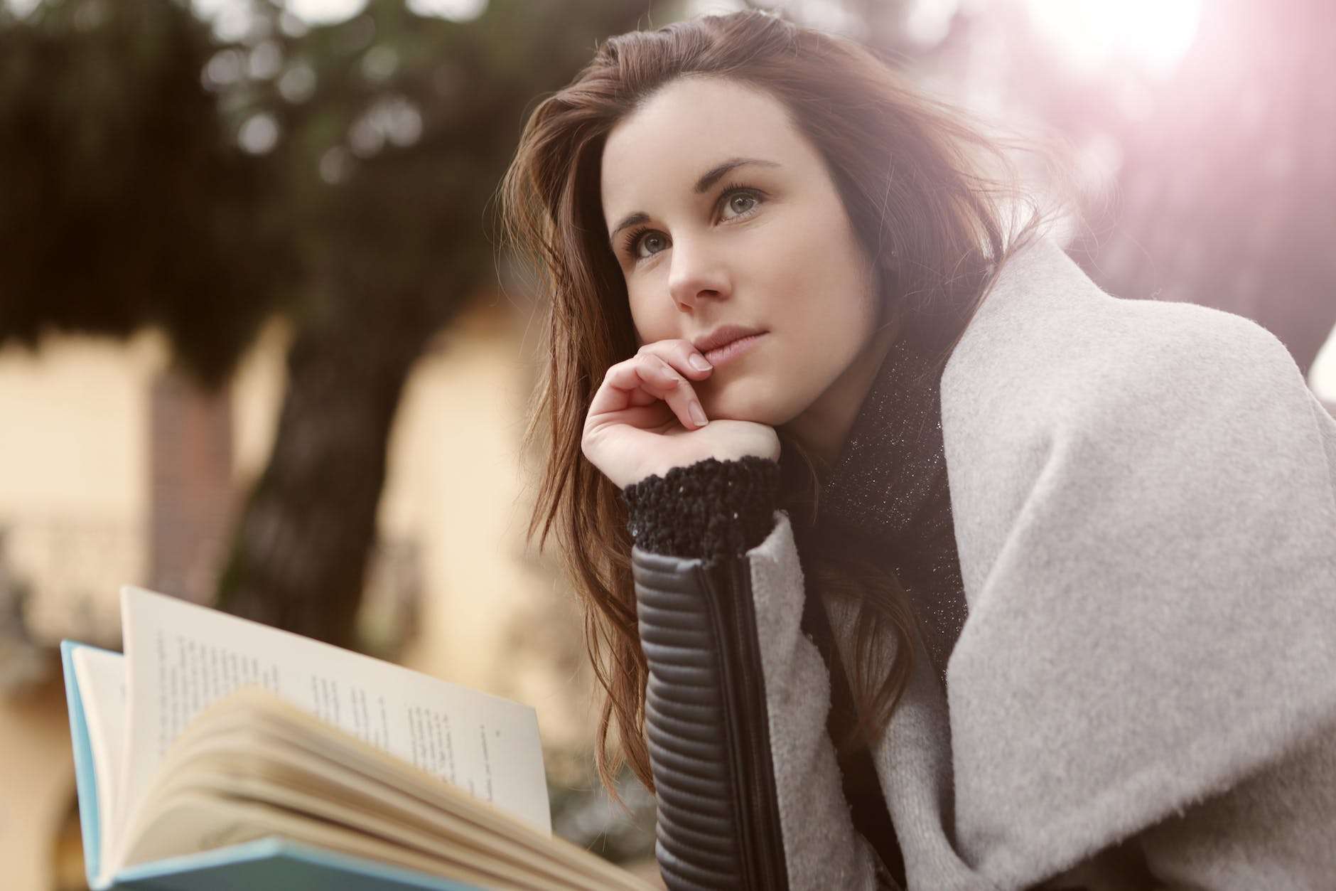 pensive woman in gray coat holding book Homeschool Mama's Thought Care Practices