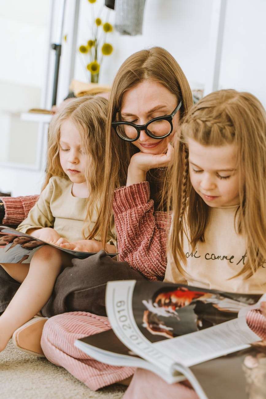 a mother and her daughters reading magazines together