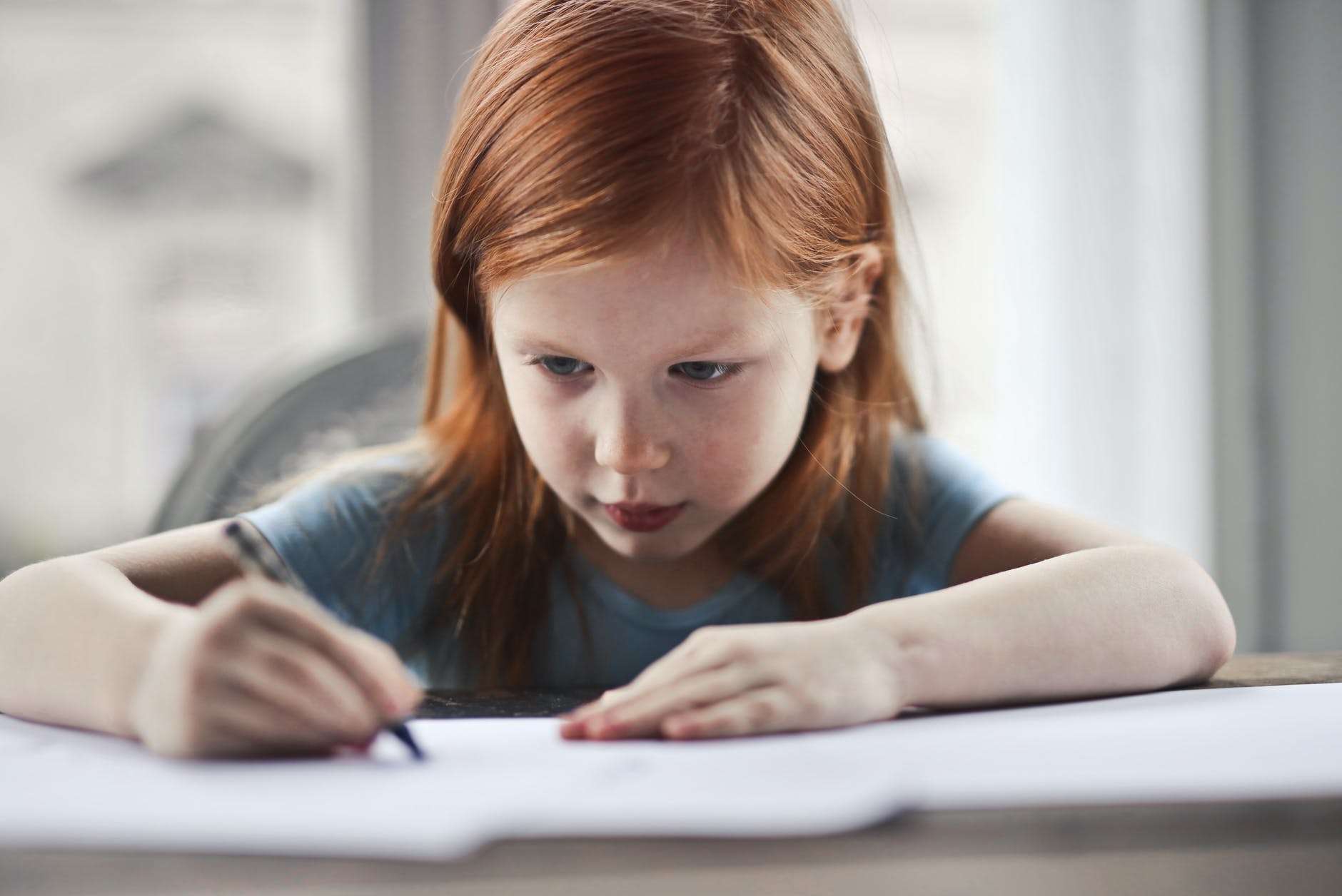 girl writing on paper: teach writing in a self-directed way