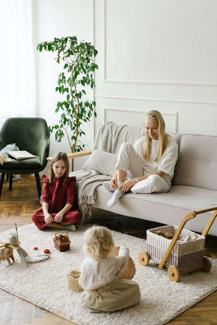 mother watching children playing with toys on soft carpet: just observe your child