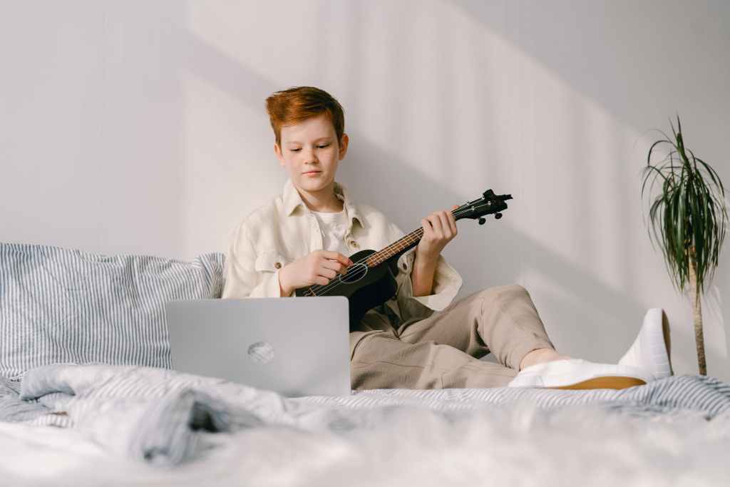 Kiddo playing ukulele: homeschool musical education