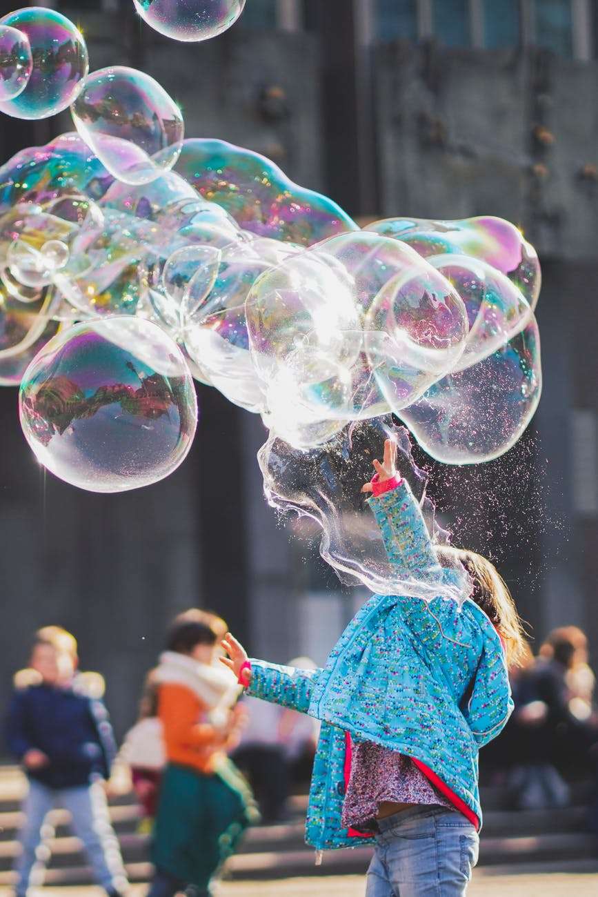 girl playing with bubbles: should I homeschool my child