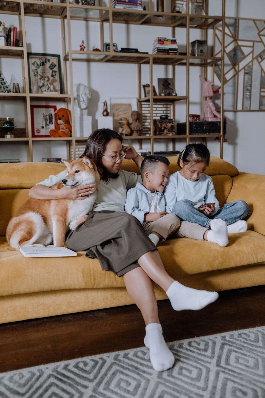 a mother sitting on the couch with her kids and their dog: nonviolent communication with kids