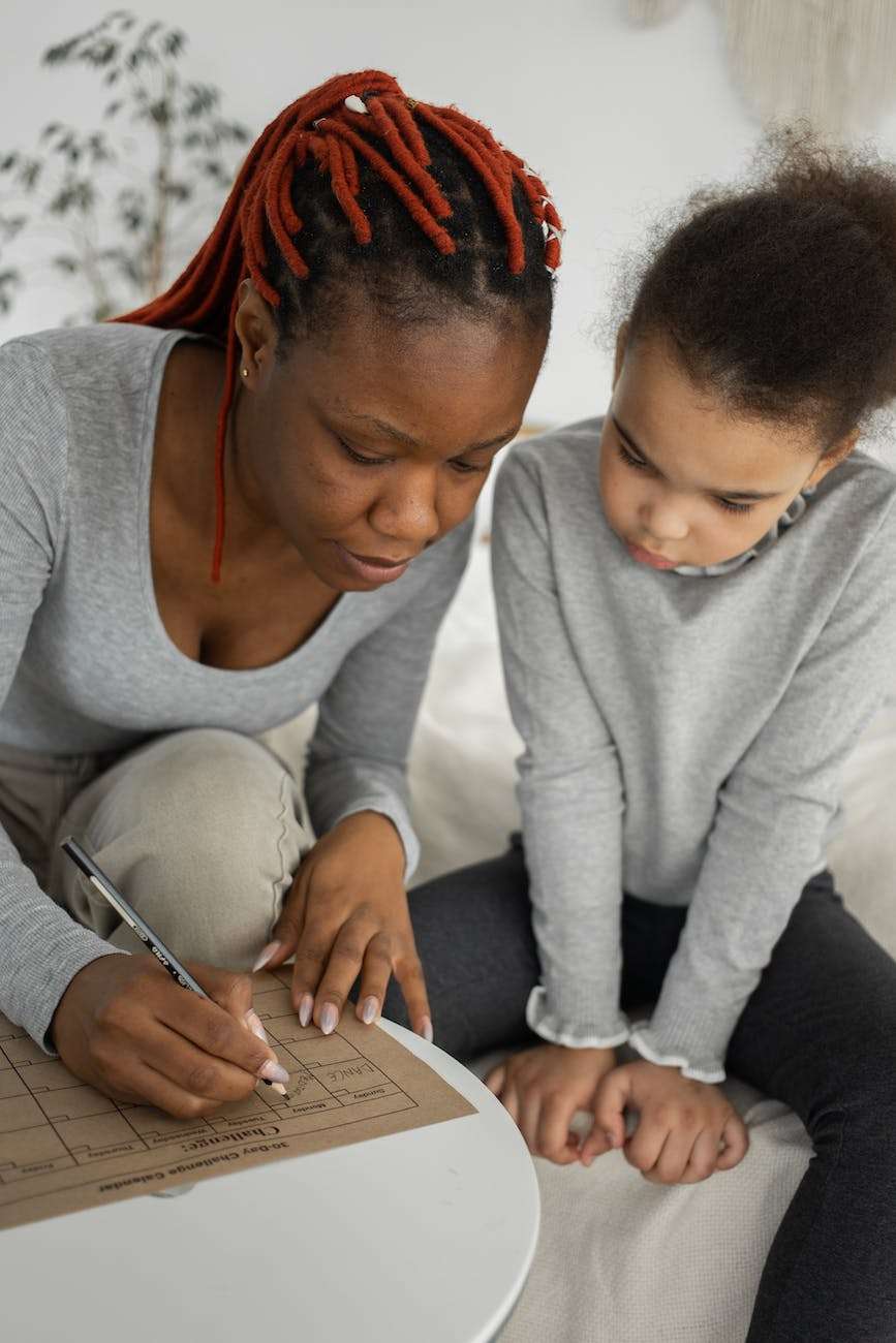 black woman with daughter drawing on paper