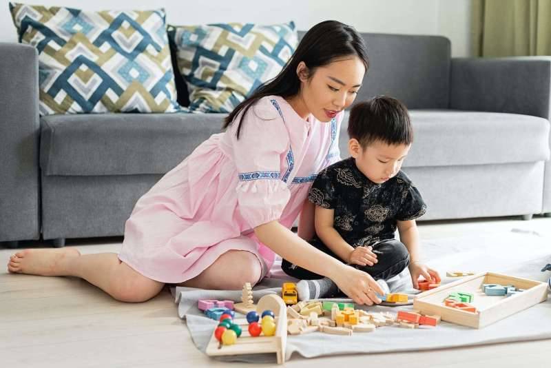 a woman and boy playing toys together