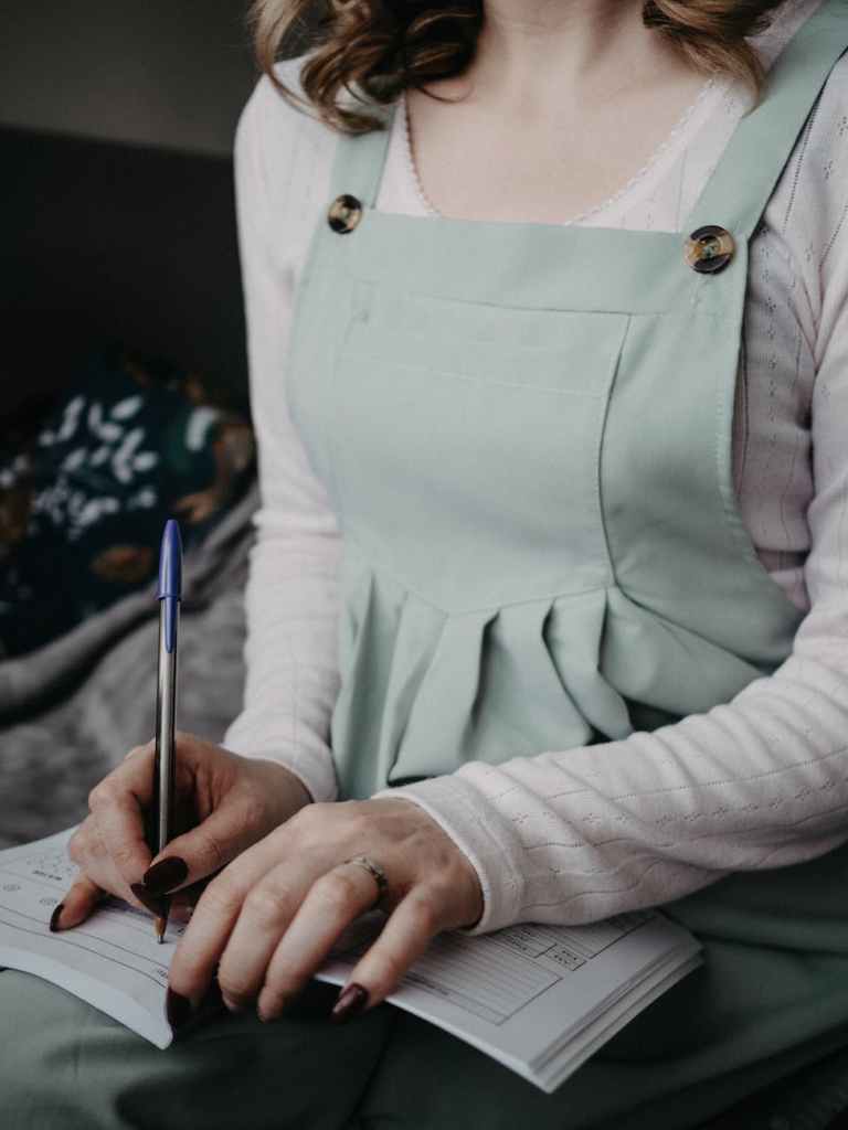 woman writing in journal at home--Why Homeschool Moms Need to Write