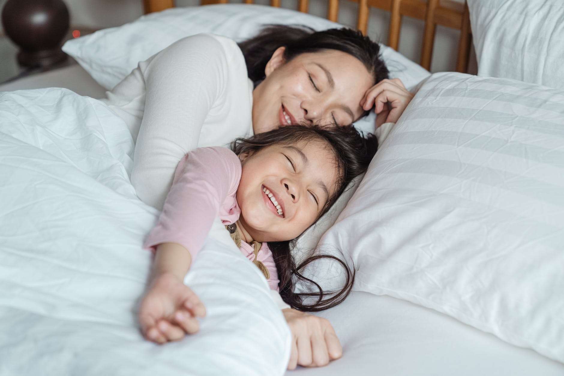 cheerful mother and daughter resting in bed: homeschool relationships
