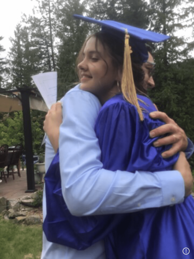 Graduation day — a homeschool high school hug with dad.