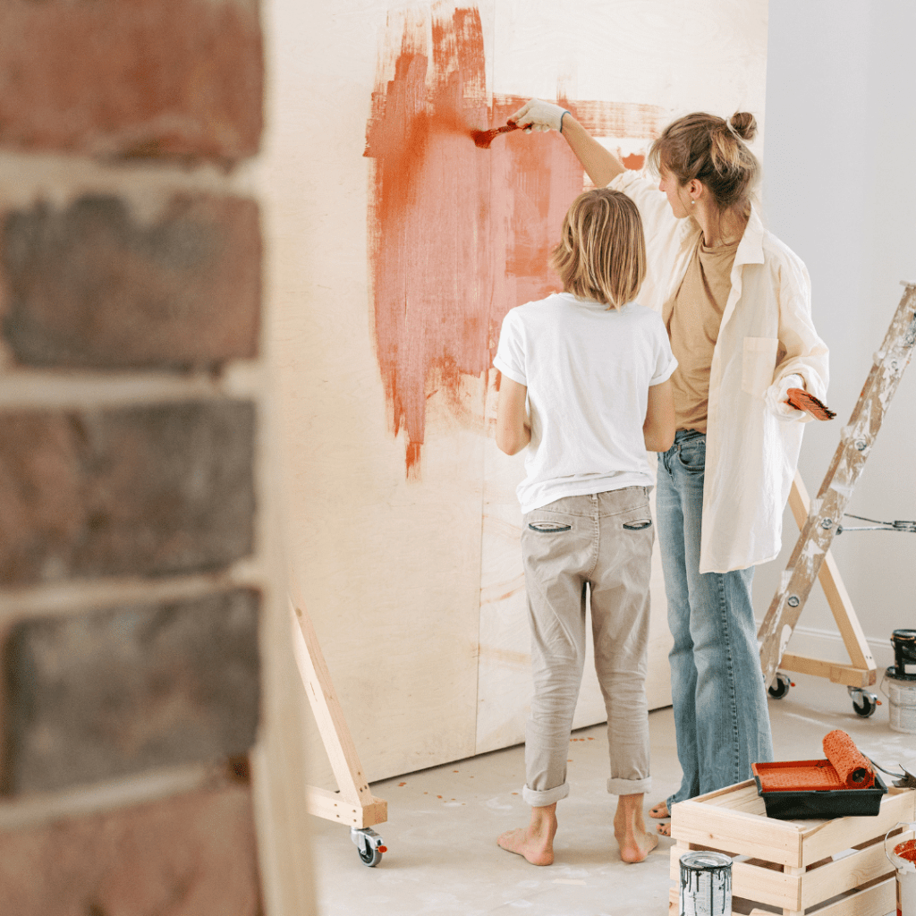 Homeschool mom and teenage daughter painting a wall together, reflecting Enneagram self-awareness and connection in the home