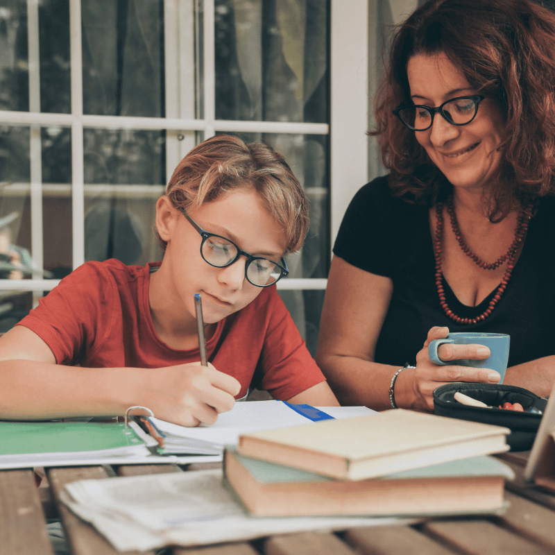 A homeschool mom sitting with her teenage son, smiling and engaged in conversation, learning to stop second-guessing as a homeschool mom while building connection.