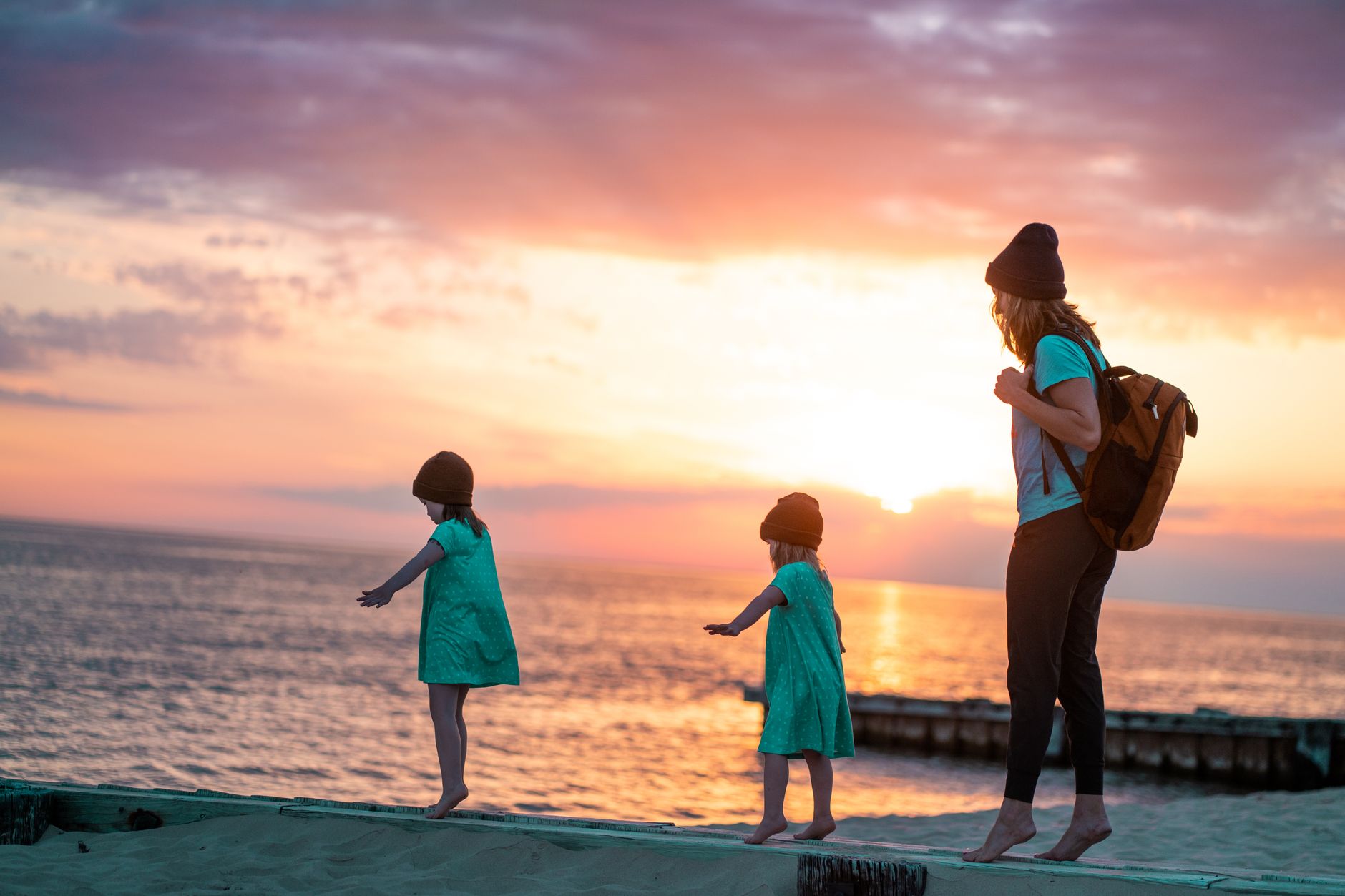 Homeschool mom playing with her daughters on the seashore, enjoying the energy freed up by reducing decision fatigue