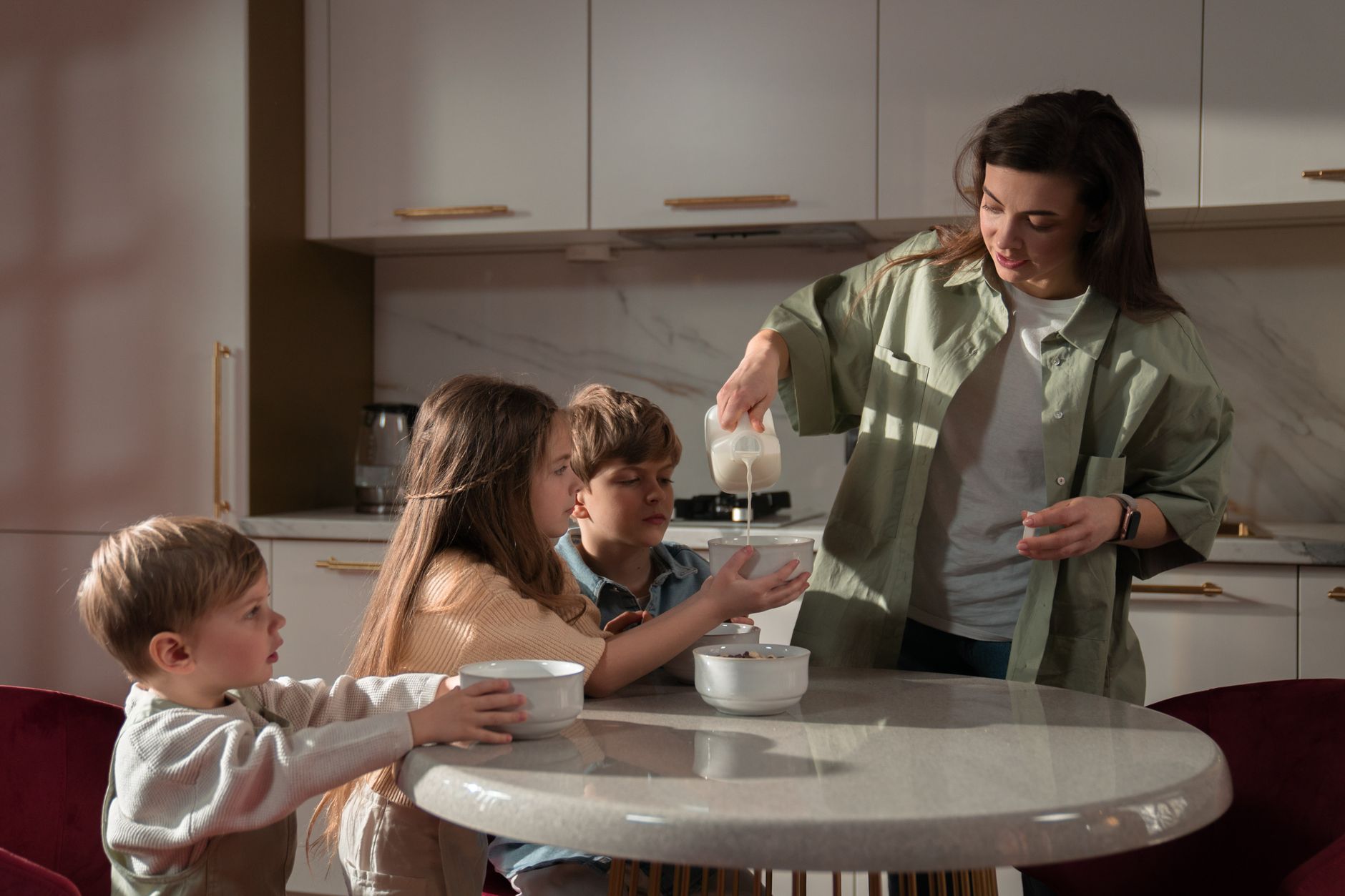 a mother pouring milk on her daughter s bowl