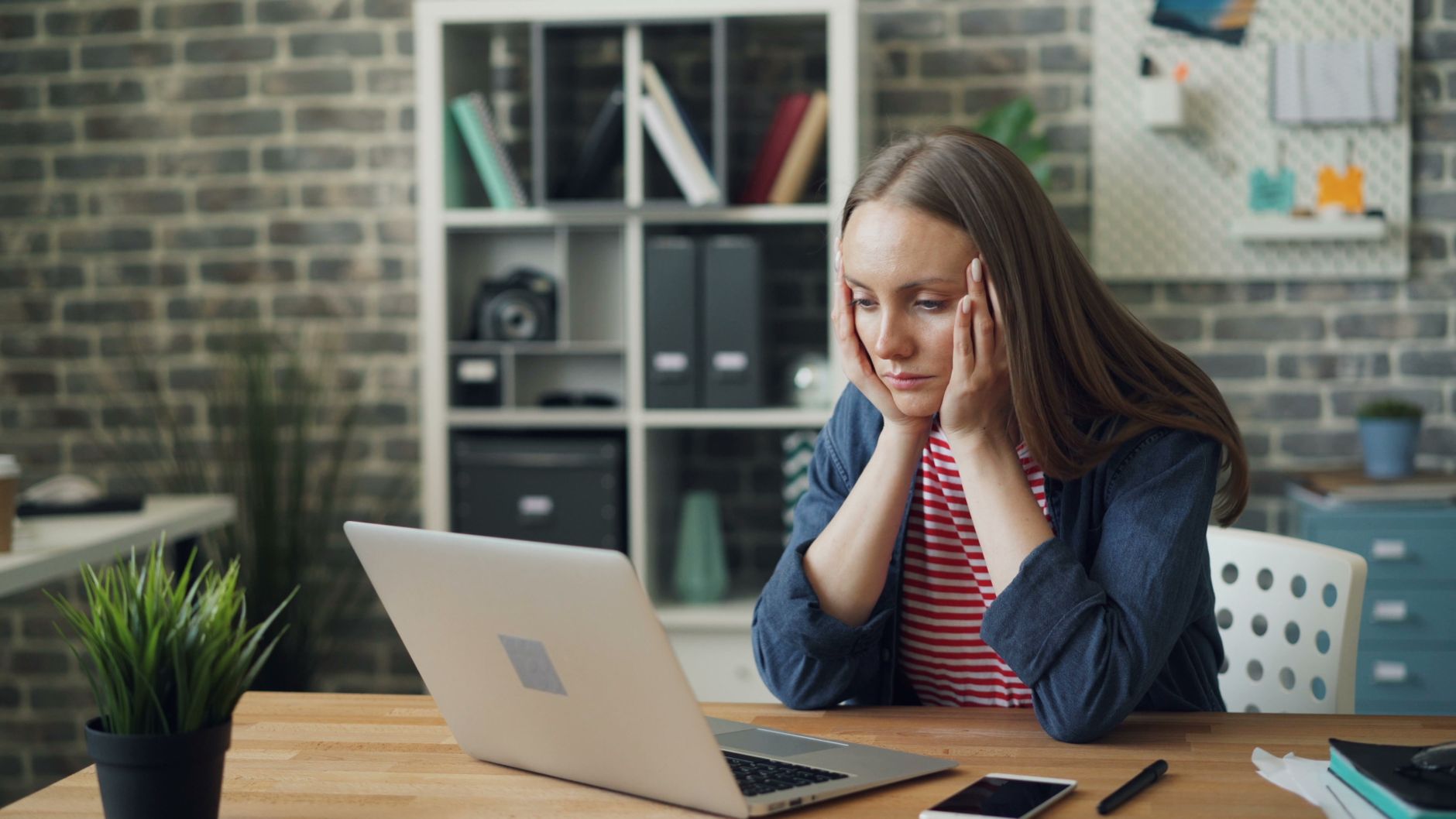 A worried woman looking at her computer screen, thinking about homeschool mom anger